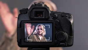 blonde women filming herself using a camera on a tripod